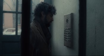 Movie still from “Inside Llewyn Davis” (2013), directed by Ethan Coen – A man standing in front of a phone booth; Medium shot, Over the shoulder angle