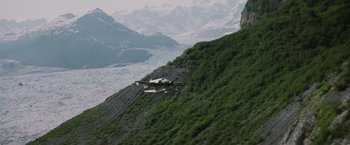 Movie still from “Insomnia” (2002), directed by Christopher Nolan – An airplane is flying low over a mountain side; Extreme Wide shot, High angle