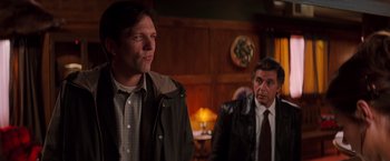 Movie still from “Insomnia” (2002), directed by Christopher Nolan – Two men in suits and ties are in a room; Medium shot, Over the shoulder angle