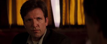 Movie still from “Insomnia” (2002), directed by Christopher Nolan – A person wearing a suit and tie; Close Up shot, Over the shoulder angle