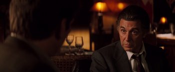 Movie still from “Insomnia” (2002), directed by Christopher Nolan – A person sitting at a table with wine glasses; Close Up shot, Over the shoulder angle