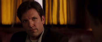 Movie still from “Insomnia” (2002), directed by Christopher Nolan – A person wearing a suit and tie; Close Up shot, Over the shoulder angle