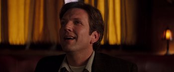 Movie still from “Insomnia” (2002), directed by Christopher Nolan – A person wearing a suit and tie; Close Up shot, Low angle