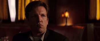 Movie still from “Insomnia” (2002), directed by Christopher Nolan – A person wearing a suit and tie; Close Up shot, Low angle