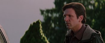 Movie still from “Insomnia” (2002), directed by Christopher Nolan – A person with trees in the background; Close Up shot, Low angle