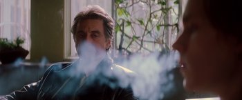 Movie still from “Insomnia” (2002), directed by Christopher Nolan – A man in a black jacket is smoking a cigarette; Close Up shot, Low angle
