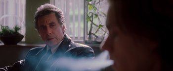 Movie still from “Insomnia” (2002), directed by Christopher Nolan – A man sitting next to another man in front of a window; Close Up shot, Over the shoulder angle