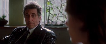 Movie still from “Insomnia” (2002), directed by Christopher Nolan – A person sitting in a room; Close Up shot, Over the shoulder angle