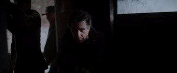 Movie still from “Insomnia” (2002), directed by Christopher Nolan – A man in a dark room looking at the camera; Close Up shot, Low angle