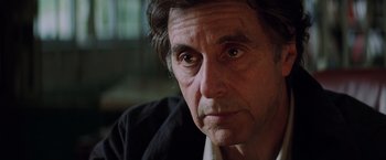 Movie still from “Insomnia” (2002), directed by Christopher Nolan – A man's face in a dark room; Close Up shot, Over the shoulder angle