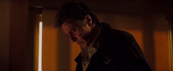 Movie still from “Insomnia” (2002), directed by Christopher Nolan – A person wearing a suit and tie; Close Up shot, Low angle