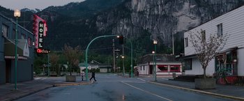 Movie still from “Insomnia” (2002), directed by Christopher Nolan – A person walking across the street in front of a building; Extreme Wide shot, High angle