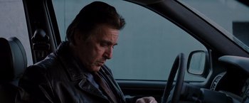Movie still from “Insomnia” (2002), directed by Christopher Nolan – A man sitting in the driver's seat of a car; Close Up shot, Low angle