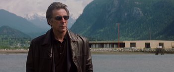 Movie still from “Insomnia” (2002), directed by Christopher Nolan – A man wearing sunglasses and a leather jacket; Medium shot, Low angle