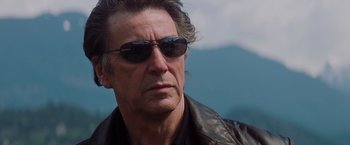 Movie still from “Insomnia” (2002), directed by Christopher Nolan – A person wearing sunglasses and a leather jacket; Close Up shot, Low angle