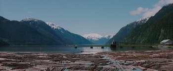 Movie still from “Insomnia” (2002), directed by Christopher Nolan – A large body of water near a mountain range; Extreme Wide shot, High angle