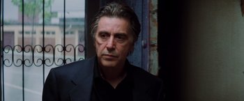 Movie still from “Insomnia” (2002), directed by Christopher Nolan – A person wearing a suit and tie; Close Up shot, Low angle