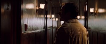Movie still from “Insomnia” (2002), directed by Christopher Nolan – A man standing in a dark room next to a window; Close Up shot, Over the shoulder angle