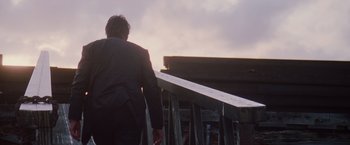 Movie still from “Insomnia” (2002), directed by Christopher Nolan – A man in a business suit walking down a ramp; Medium shot, Low angle