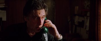 Movie still from “Insomnia” (2002), directed by Christopher Nolan – A person talking on a phone; Close Up shot, Low angle