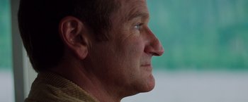 Movie still from “Insomnia” (2002), directed by Christopher Nolan – A man's face with a green background; Close Up shot, Over the shoulder angle