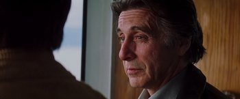 Movie still from “Insomnia” (2002), directed by Christopher Nolan – An older man looking out a window with a serious look on his face; Close Up shot, Over the shoulder angle