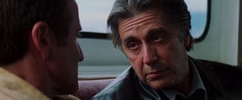 Movie still from “Insomnia” (2002), directed by Christopher Nolan – A person sitting on a couch; Close Up shot, Over the shoulder angle