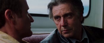 Movie still from “Insomnia” (2002), directed by Christopher Nolan – A person sitting next to another person; Close Up shot, Over the shoulder angle