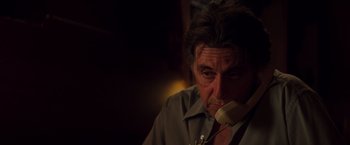 Movie still from “Insomnia” (2002), directed by Christopher Nolan – An older man is sitting down while talking on the phone; Close Up shot, Low angle