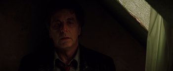 Movie still from “Insomnia” (2002), directed by Christopher Nolan – A man in a suit and tie in a dark room; Close Up shot, Low angle