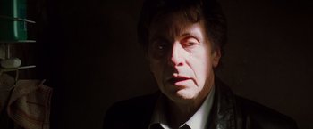 Movie still from “Insomnia” (2002), directed by Christopher Nolan – A person wearing a suit and tie; Close Up shot, Low angle