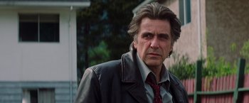 Movie still from “Insomnia” (2002), directed by Christopher Nolan – A person wearing a suit and tie; Close Up shot, Low angle