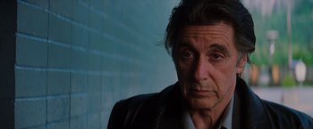 Movie still from “Insomnia” (2002), directed by Christopher Nolan – A person wearing a suit and tie; Close Up shot, Low angle