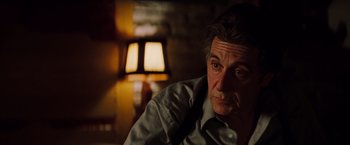 Movie still from “Insomnia” (2002), directed by Christopher Nolan – A person sitting in front of a lamp; Close Up shot, Over the shoulder angle