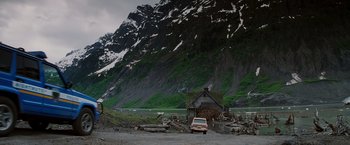 Movie still from “Insomnia” (2002), directed by Christopher Nolan – A car parked in front of a house in the mountains; Extreme Wide shot, High angle