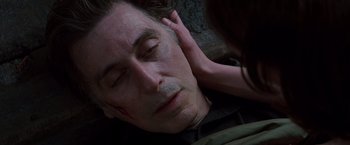 Movie still from “Insomnia” (2002), directed by Christopher Nolan – A man laying on the ground next to a woman's hand; Close Up shot, Overhead angle