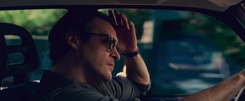 Movie still from “Irrational Man” (2015), directed by Woody Allen – A man sitting in the back seat of a car; Close Up shot, Over the shoulder angle