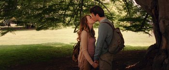 Movie still from “Irrational Man” (2015), directed by Woody Allen – A man and a woman kissing under a tree in a park; Medium shot, Low angle