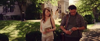 Movie still from “Irrational Man” (2015), directed by Woody Allen – A woman standing next to a man holding a book; Medium shot, Over the shoulder angle