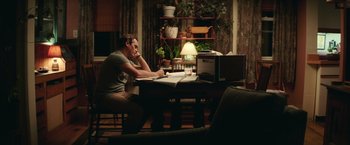 Movie still from “Irrational Man” (2015), directed by Woody Allen – A man sitting at a table in front of a computer; Medium shot, Over the shoulder angle