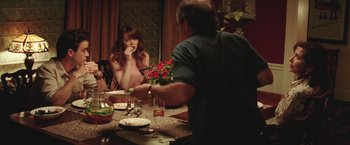 Movie still from “Irrational Man” (2015), directed by Woody Allen – A woman sitting at a dinner table looking at a man; Medium shot, Over the shoulder angle