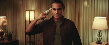 Movie still from “Irrational Man” (2015), directed by Woody Allen – A man holding a gun up to his head; Close Up shot, Over the shoulder angle