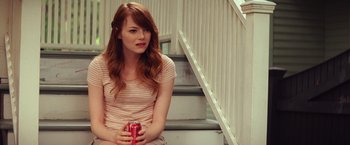 Movie still from “Irrational Man” (2015), directed by Woody Allen – A woman sitting on the stairs holding a can of soda; Medium shot, Over the shoulder angle