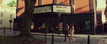 Movie still from “Irrational Man” (2015), directed by Woody Allen – Two people walking down the street in front of a movie theater; Extreme Wide shot, High angle