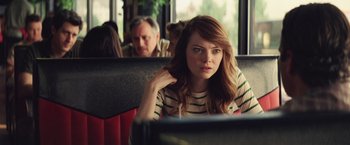 Movie still from “Irrational Man” (2015), directed by Woody Allen – A woman sitting on a bus with her hand on her chin; Close Up shot, Over the shoulder angle