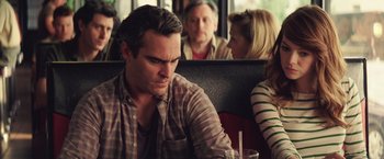 Movie still from “Irrational Man” (2015), directed by Woody Allen – A man sitting at a table in front of two other people; Close Up shot, Over the shoulder angle