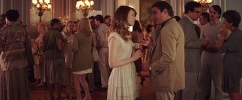 Movie still from “Irrational Man” (2015), directed by Woody Allen – A man and a woman talking to each other in front of a group of people; Medium shot, Over the shoulder angle