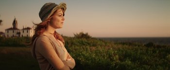 Movie still from “Irrational Man” (2015), directed by Woody Allen – A woman standing in the grass with her arms crossed; Close Up shot, Over the shoulder angle