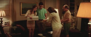 Movie still from “Irrational Man” (2015), directed by Woody Allen – A group of people standing in a living room; Medium shot, Over the shoulder angle