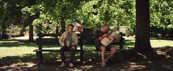 Movie still from “Irrational Man” (2015), directed by Woody Allen – Two men sitting on a park bench reading newspapers; Wide shot, Over the shoulder angle
